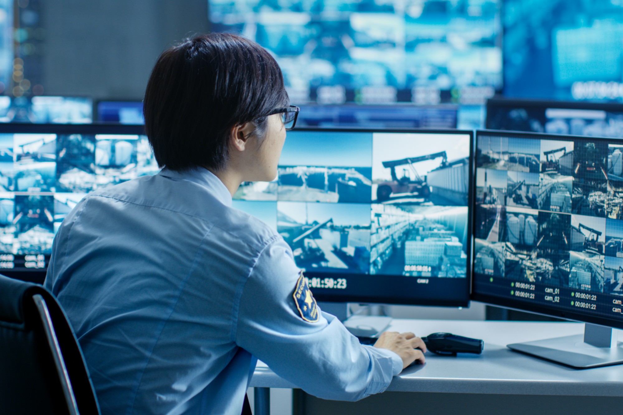 Security officer monitoring multiple surveillance screens.